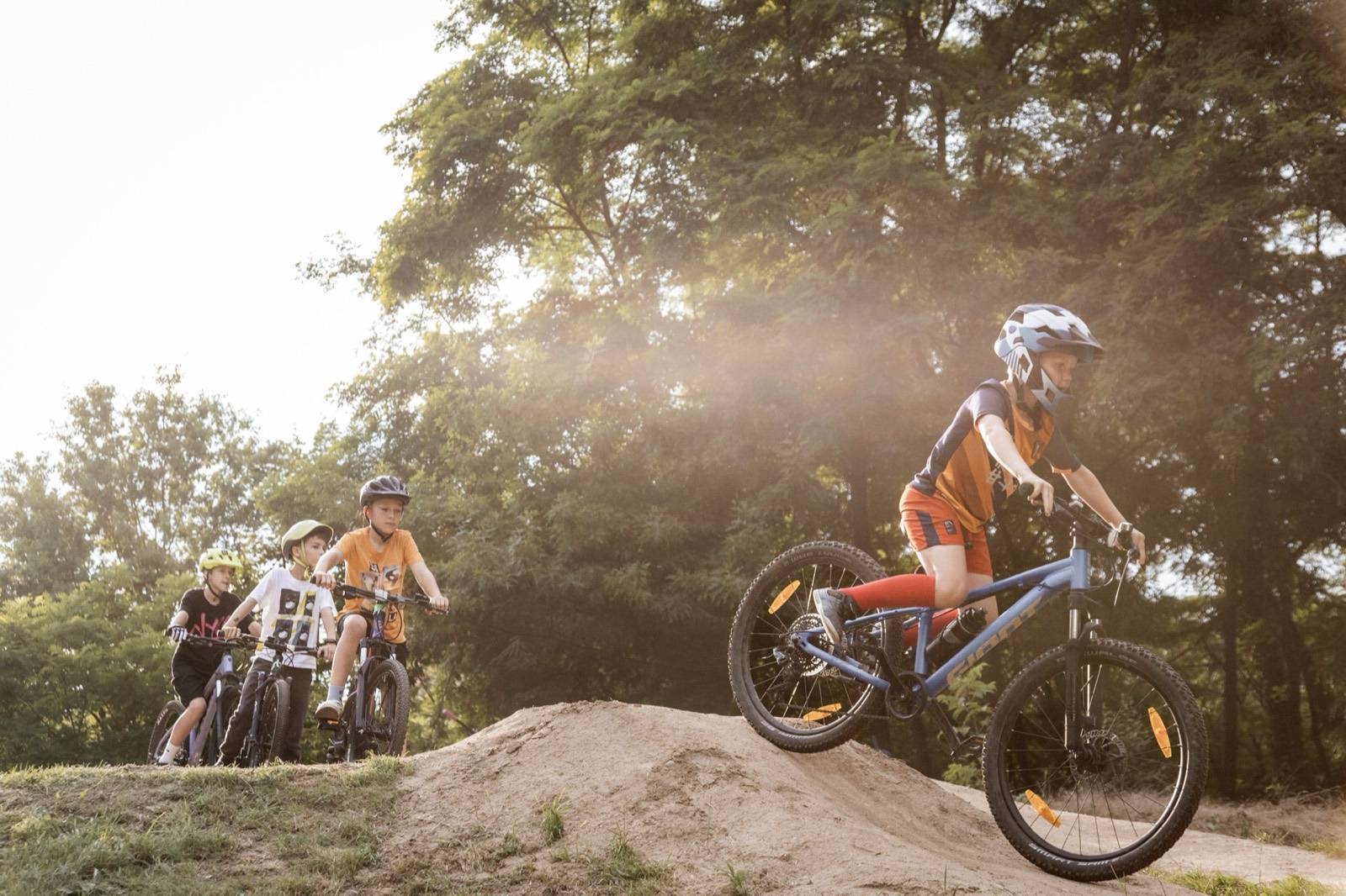 Dziecko na rowerze w locie nad hopką podczas treningu Akademii Rowerowej Frajdy