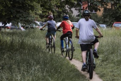 Trener prowadzi dzieci ścieżką przez park