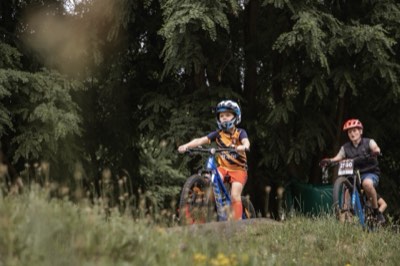 Dwoje dzieci na rowerach na łące pełnej traw