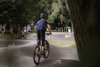 Chłopiec wjeżdża na pumptrack w parku